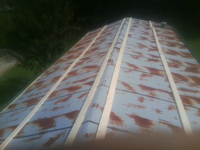Rusted metal roof panels with new wood purlins before replacement — Storm Damage Roof Repair in Black Eagle by Roofing Brothers