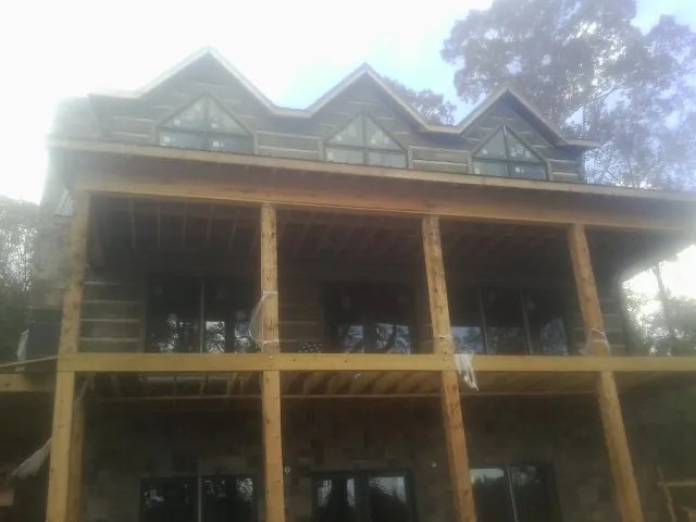 Dormers and porch framing on a large log home under construction — Roof Coating work by our crew in Black Eagle